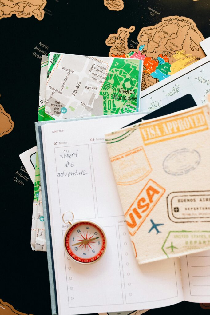 Home Flat lay of travel essentials including compass, notebook, and map for a journey.